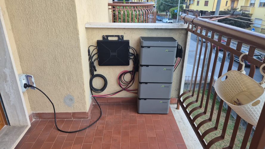 Italian apartment balcony with a four-module stacked LIONSHEE battery, wall-mounted unit and cable run to a domestic socket