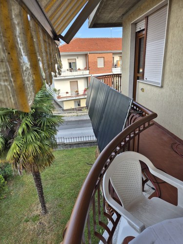 Solar panel mounted on the railing of an Italian apartment balcony overlooking a residential street