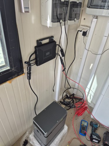 Wall-mounted microinverter with a LIONSHEE battery module below it during commissioning at a Polish installation